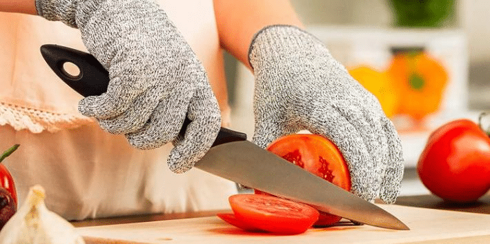 Person wearing cut resistant gloves while slicing vegetables